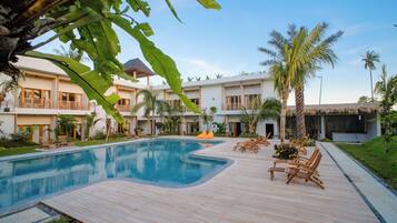 Una piscina al aire libre, sombrillas, tumbonas