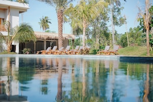 Una piscina al aire libre, sombrillas, tumbonas