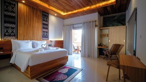 A modern hotel room with a wooden ceiling, a large bed, a desk, and a view of the outdoors. - Giri Rose Boutique Hotel (Kuta)