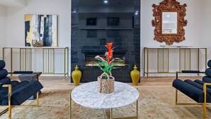 Een moderne woonkamer met een open haard, twee banken, een salontafel en decoratieve vazen.