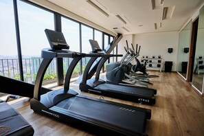 A gym with treadmills, exercise bikes, and a view of the city. - Colon: Loft with private balcony and Rooftop Pool (Ciudad de México)