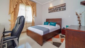 A hotel room with a bed, a desk, a chair, and a window with curtains. - Hotel Yubarta (Buenaventura)