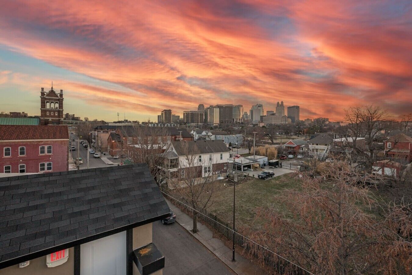 A cityscape with a prominent clock tower, a mix of residential and commercial buildings, and a clear sky.