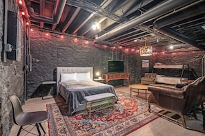 Een kamer met een bed, een bank, een klein tafeltje en een televisie.