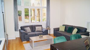 Un salón con dos sofás, una mesa de centro y vistas amplias a través de grandes ventanales.