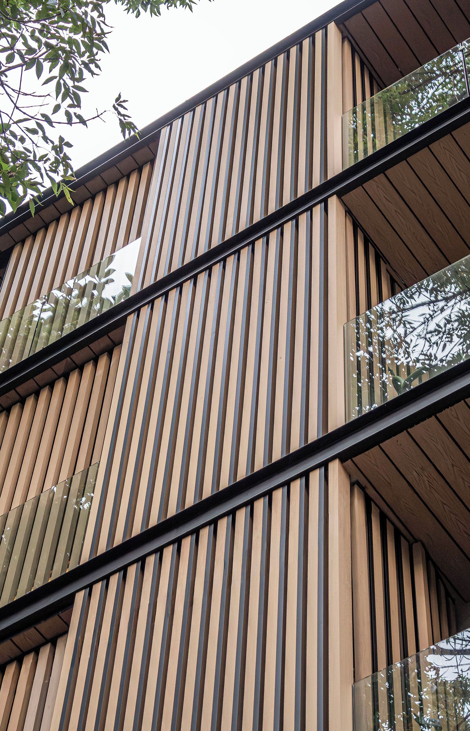 A building with vertical wooden slats and glass balconies.