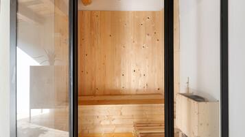 Een kamer met houten paneelwanden, een glazen deur en een kleine houten constructie aan het einde van de kamer.