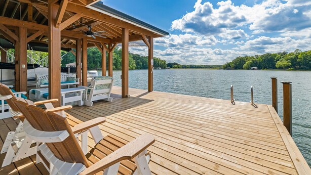 Una terrassa de fusta amb caires i una zona coberta amb vista a un llac.