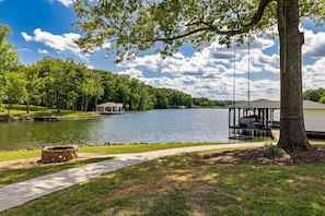 A lakeside view with a gazebo, a dock, and a walking path.