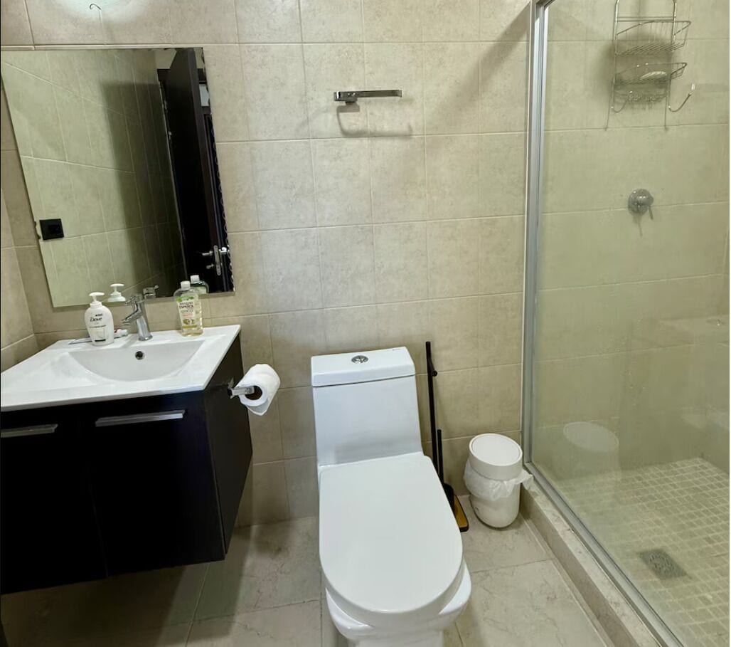 A bathroom with a white sink, toilet, and shower.
