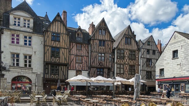A traditional European street with half-timbered buildings, outdoor seating, and a visible storefront. - Cosy studio près des châteaux de la Loire (Amboise)