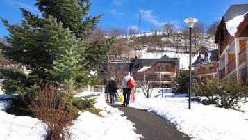 A snow-covered path leading to buildings with a clear sky.