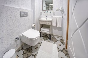 A bathroom with a toilet, sink, and mirror. - Taksim Square - Deluxe Studio 302 (Istanbul)