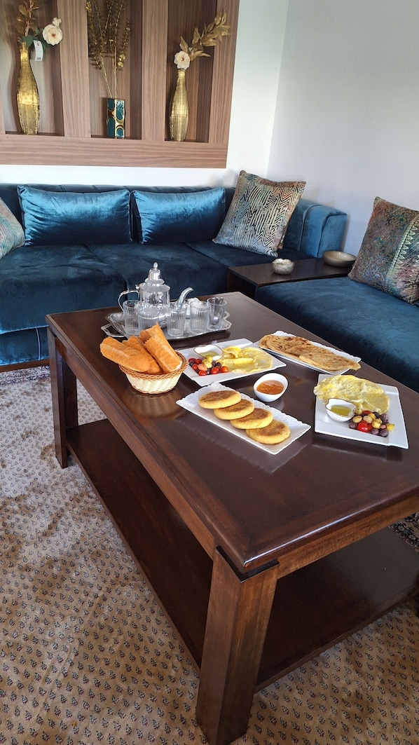 A dining table set with breakfast items, a sofa, and decorative vases in the background. - villa moderne au centre de Rabat (Rabat)