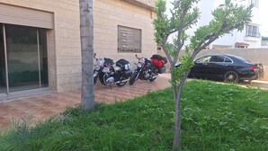 A building with a tiled entrance, a parked motorcycle, and a car.