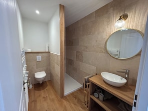 Une salle de bain moderne équipée de toilettes, d’une douche et d’un lavabo.