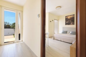 Ein Hotelzimmer mit einem Bett, einem Schreibtisch, einem Sessel und einem Gemälde an der Wand.