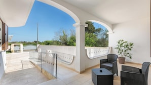 A covered outdoor area with a seating arrangement, a potted plant, and a view of a gate and greenery. - Ulivo di Rocco - Bilo Standard PT by BarbarHouse (Cannole)