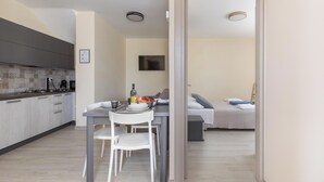 Eine moderne Küche mit Essbereich, ein Bett und ein Fernseher im Schlafzimmer.