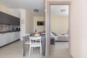 Una cucina moderna con zona pranzo, un letto e una TV in camera da letto.