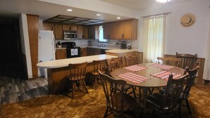A compact kitchen with wooden cabinets, a microwave, and a refrigerator.