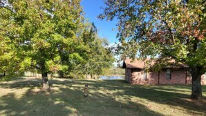 A grassy area with trees and a brick building.
