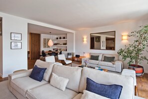 Ein modernes Wohnzimmer mit einer Couch, einem Essbereich und einer Spiegelwand.