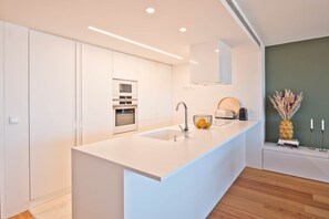 Eine moderne Küche mit einer großen Kochinsel, einem eingebauten Backofen und einem minimalistischen Design.