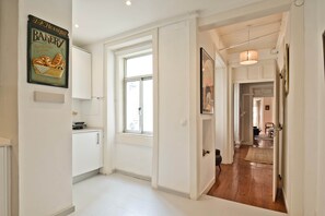Eine Küche mit weißen Schränken, einem Fenster und einem Schild für eine Bäckerei an der Wand.