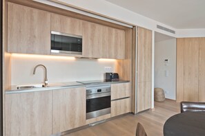 Eine moderne Küche mit Holzausstattung, Edelstahlgeräten und einer eingebauten Mikrowelle.