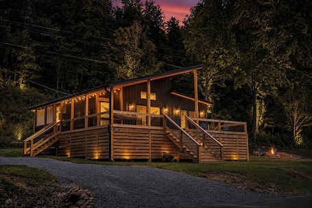 A wooden cabin with a deck, stairs, and a fire pit.. Riverside Retreat - new 2-bed 2-bath modern cabin on North Fork of the Holston