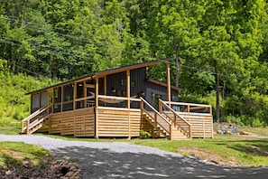 Una baita con facciata in legno, una veranda coperta e una scala che conduce all'ingresso.
