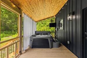 Un jacuzzi en un área de terraza de madera con vistas a la vegetación.