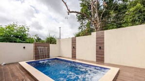 A rectangular outdoor swimming pool with a tiled edge, surrounded by a wooden deck and a low wall with a tiled pattern. - Private 3BR Villa Yard Pool Gated Sleeps 8 (La Romana)
