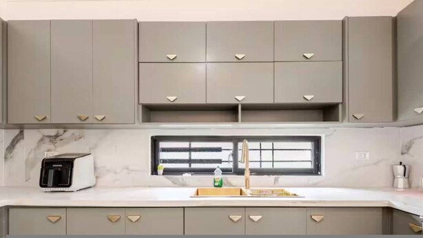 A kitchen with grey cabinets, a built-in toaster, a window with blinds, and a marble countertop. - Private 3BR Villa Yard Pool Gated Sleeps 8 (La Romana)