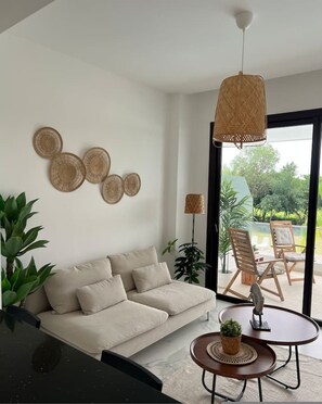 Ein modernes Wohnzimmer mit einer Couch, einem Couchtisch und einer Pendelleuchte.