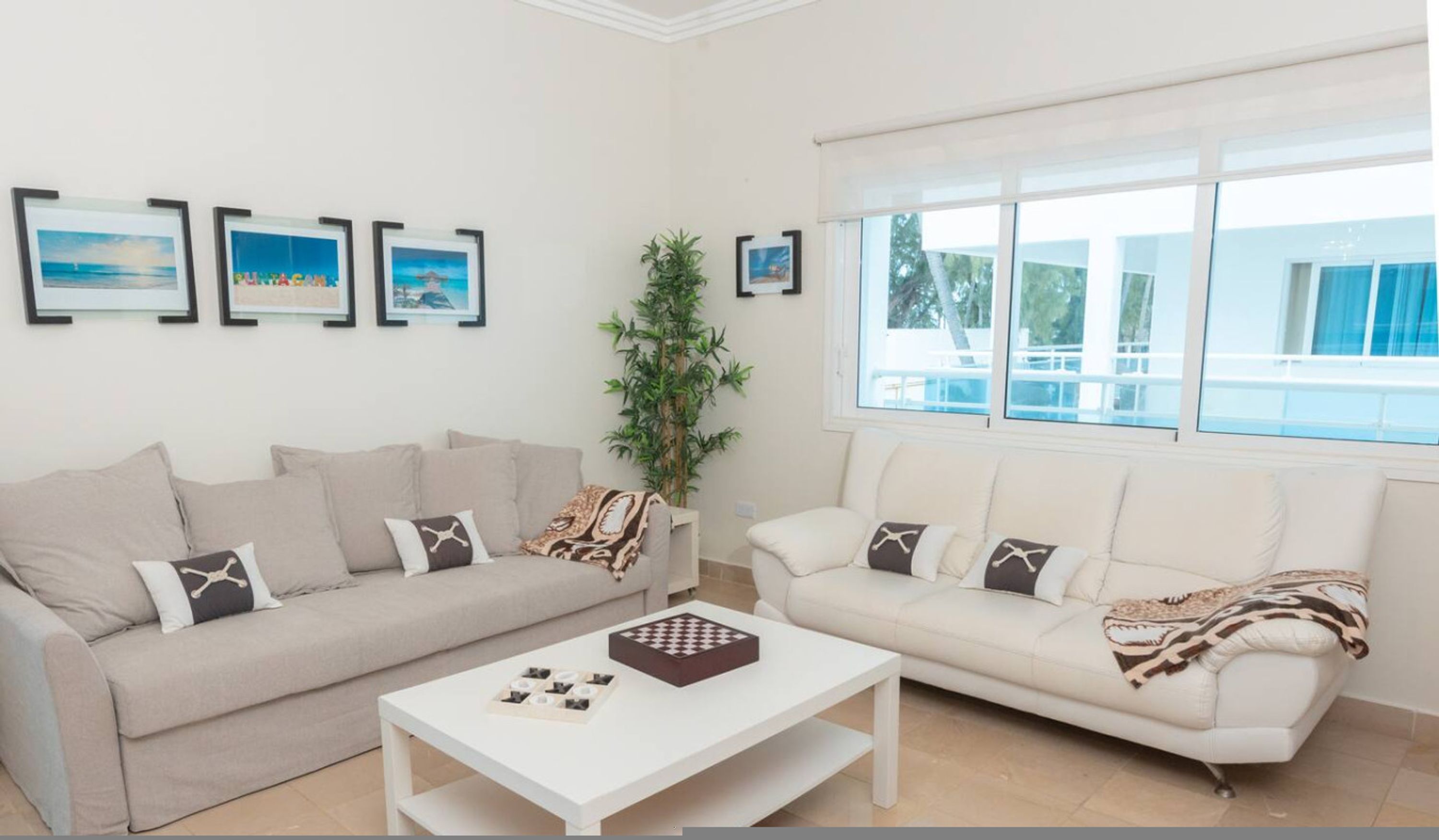 A living room with two sofas, a coffee table, and framed pictures on the wall.