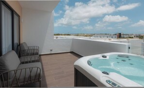 Ein Balkon mit Whirlpool, einer Couch und Blick auf die Stadtlandschaft.