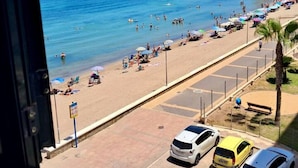 A beach with people, umbrellas, and cars. - Beachfront 3BR Condo w Pool Views Sleeps 10 (San Javier)