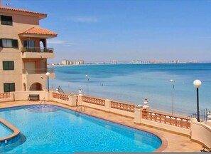 Une piscine avec vue sur la mer et les bâtiments situés au loin.