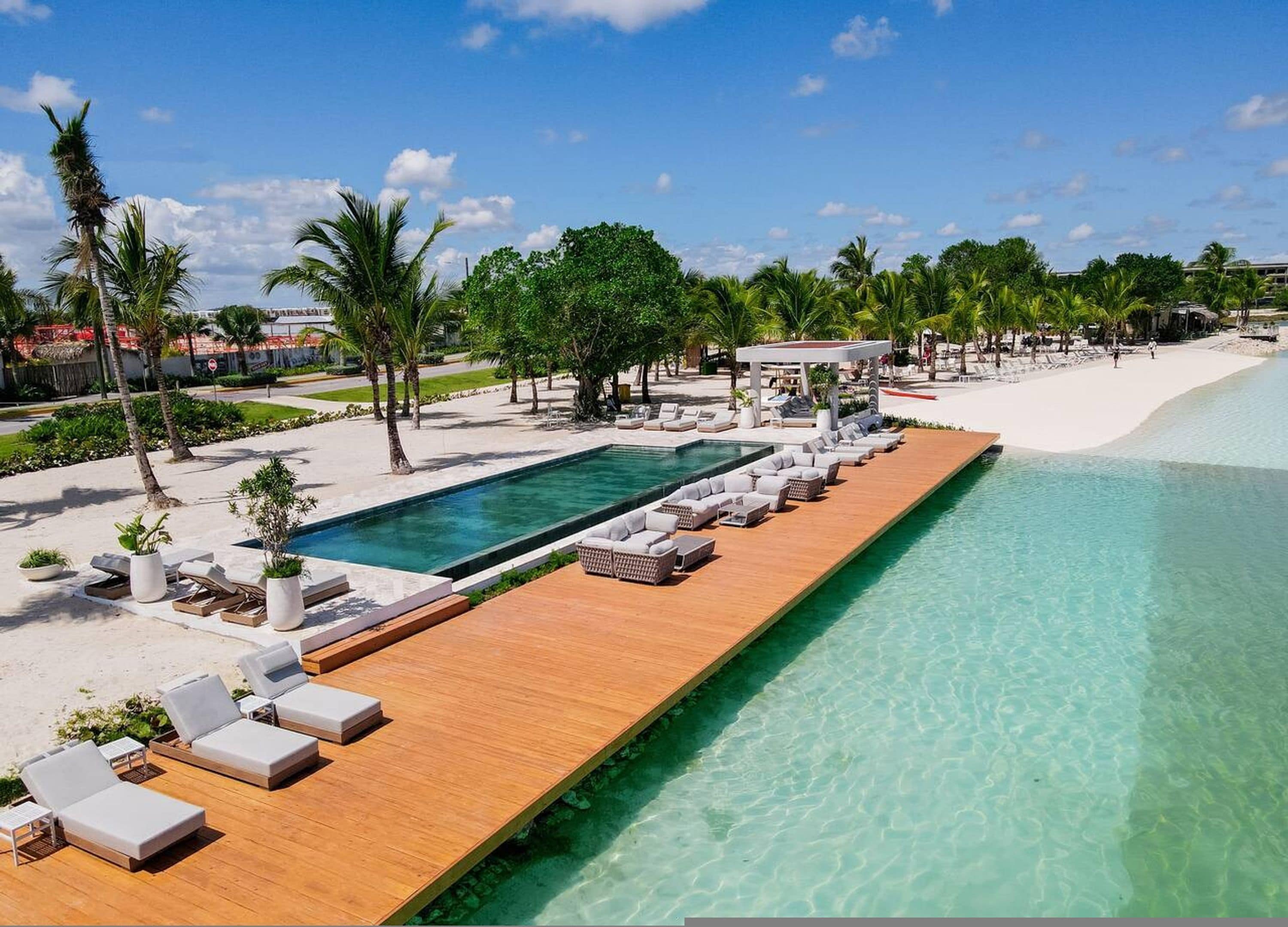 A resort with a long wooden deck, a swimming pool, and a beach.