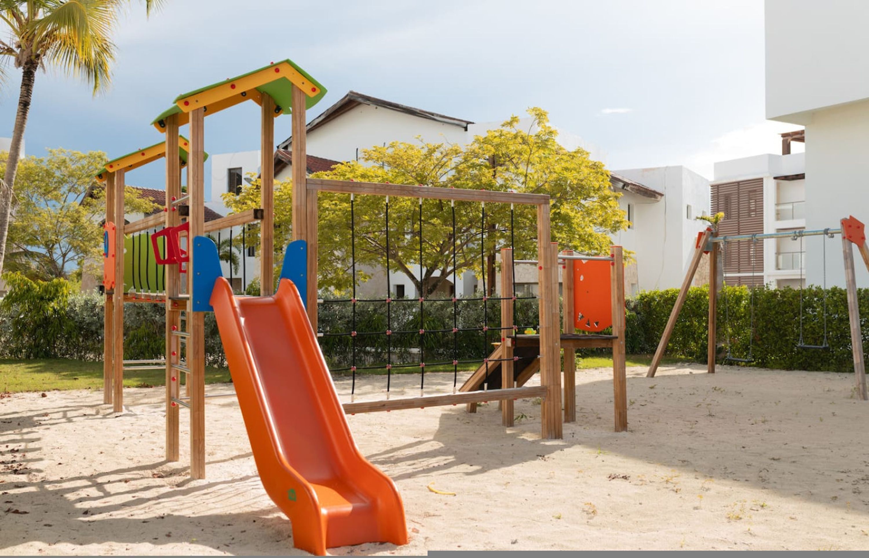 Een speeltuin met een glijbaan, klimconstructies en schommels.