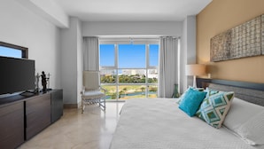 Una camera d'albergo con un letto, una televisione, una scrivania e vista su un campo da golf.