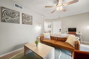 A living room with a sofa, a coffee table, and wall art.