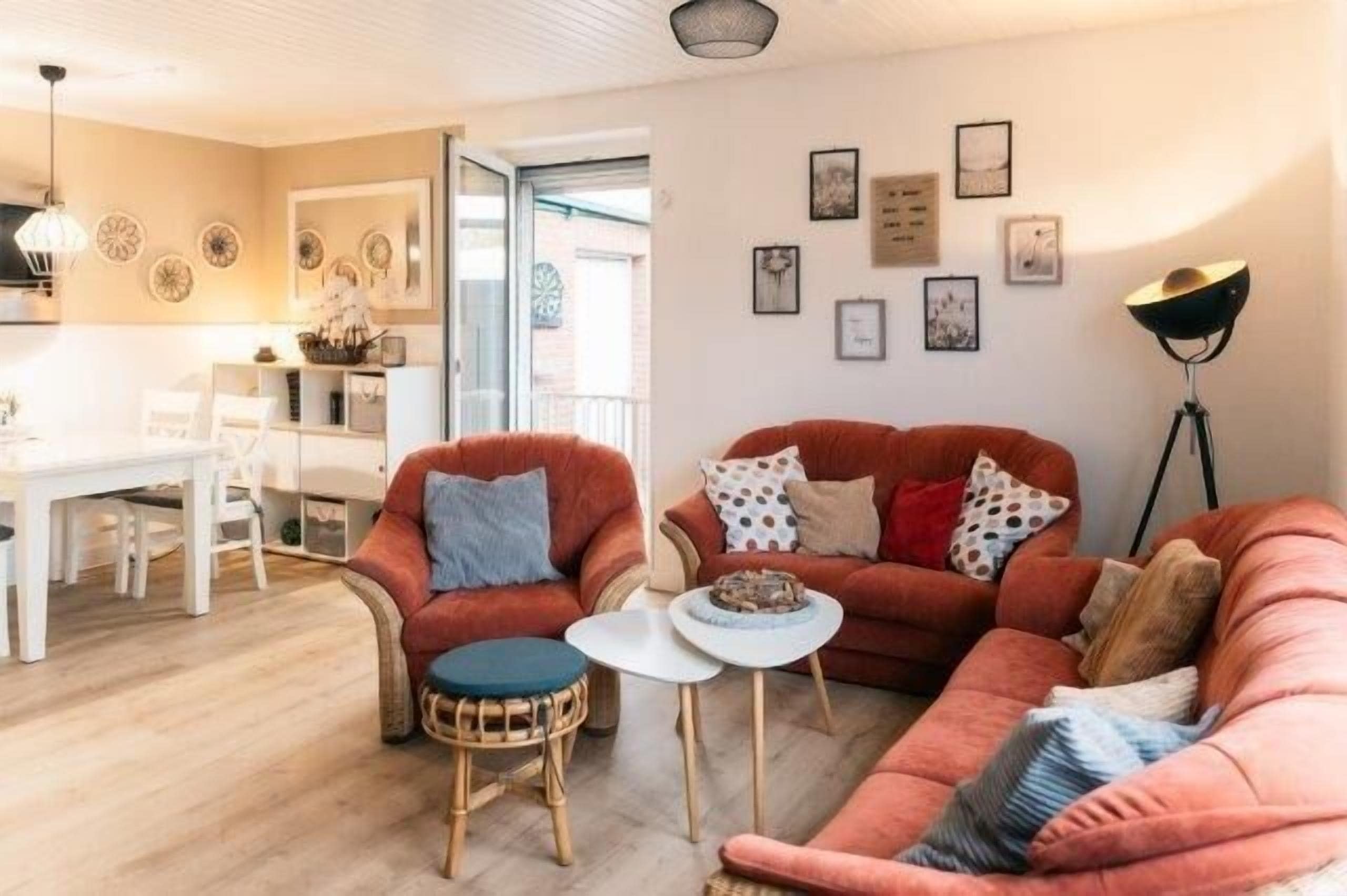 A living room with a sofa, chairs, a small table, and a floor lamp.