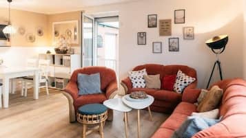 A living room with a sofa, chairs, a small table, and a floor lamp.