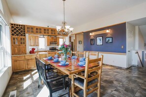 Een eetruimte met een houten tafel, gedekt voor vier personen, omringd door houten stoelen.