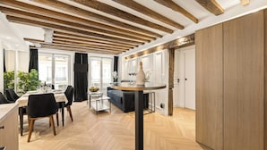 Um interior moderno com uma área de refeições, uma mesa redonda e um padrão de piso em padrão herringbone.