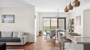 Una cocina moderna con barra, una mesa de comedor con sillas y un sofá en la sala.