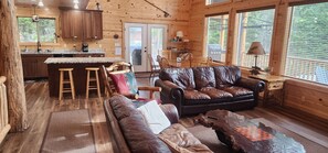 Ein Holzblockhaus-Interieur mit Küche, Essbereich und Wohnzimmer.